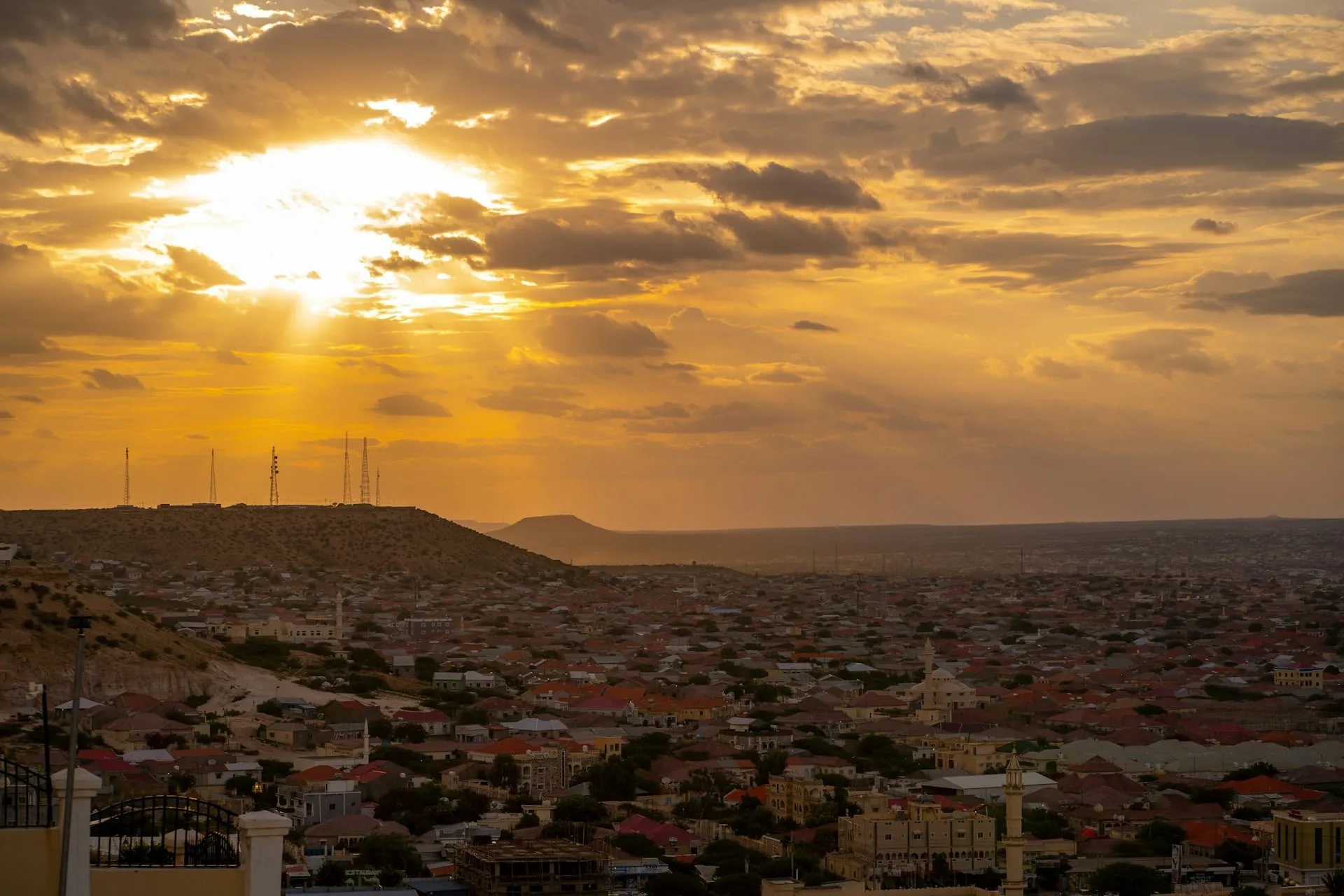 The sun setting over a city and hills